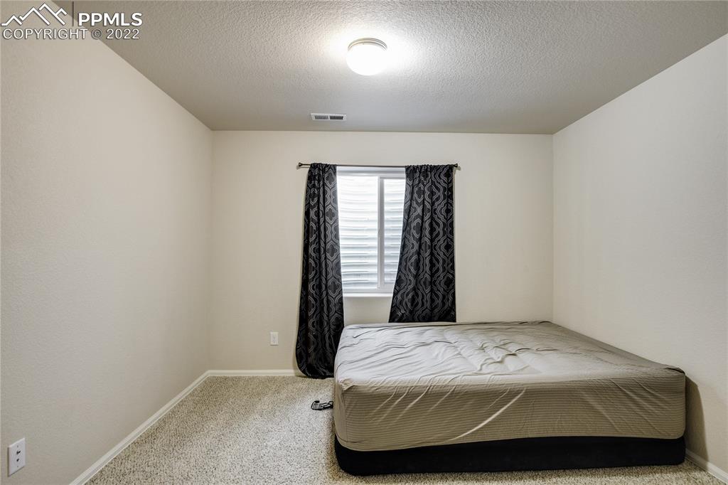 6446 Dancing Moon Way Colorado Springs, CO 80911 - Photo 28 of 42 a bedroom with a bed and a window