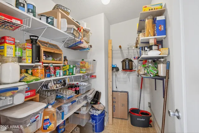 a view of an empty room with window and chandelier fan