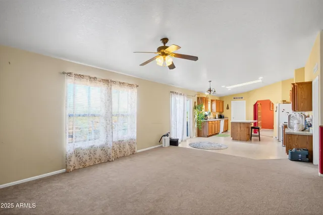 an empty room with windows and fan