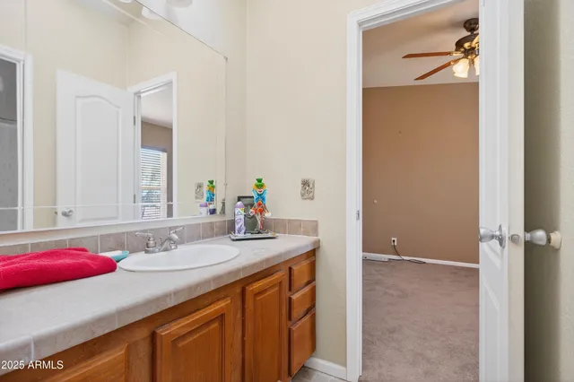 a bathroom with a sink a toilet a mirror and shower curtain