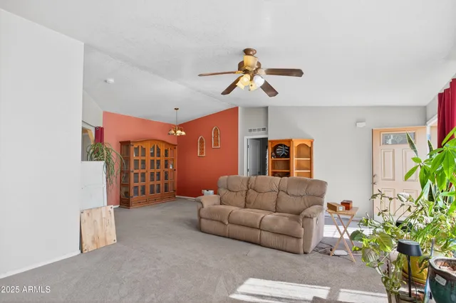 a living room with furniture flowers and a window