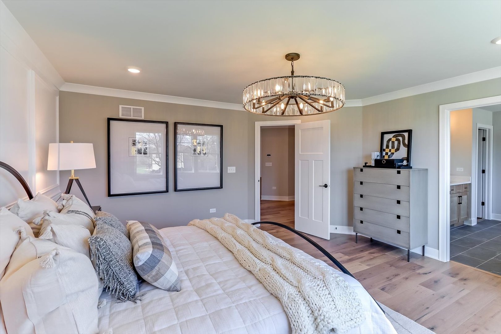 10733 Chadsey Road Huntley, IL 60142 - Photo 22 of 30 a bedroom with a large bed and a chandelier