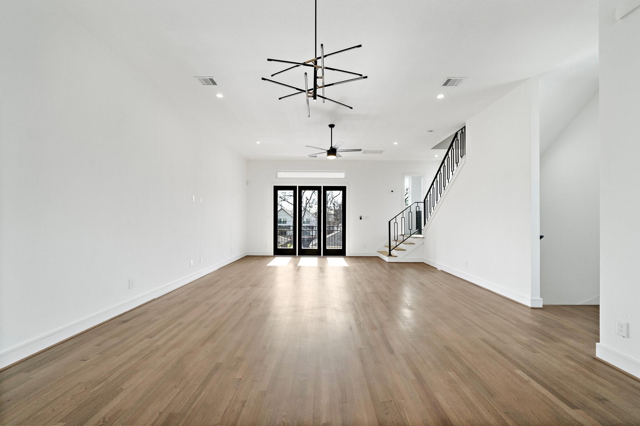 1005 East 28th Street Houston, TX 77009 - Photo 12 of 35 a view of an empty room with wooden floor ceiling fan and a window