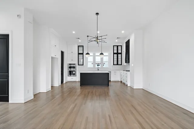 a view of a kitchen with wooden floor and electronic appliances