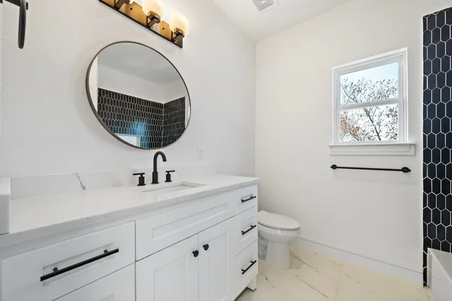a bathroom with a toilet a sink and mirror