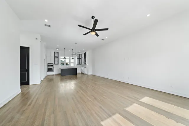a view of a kitchen with a sink and dishwasher a refrigerator with wooden floor