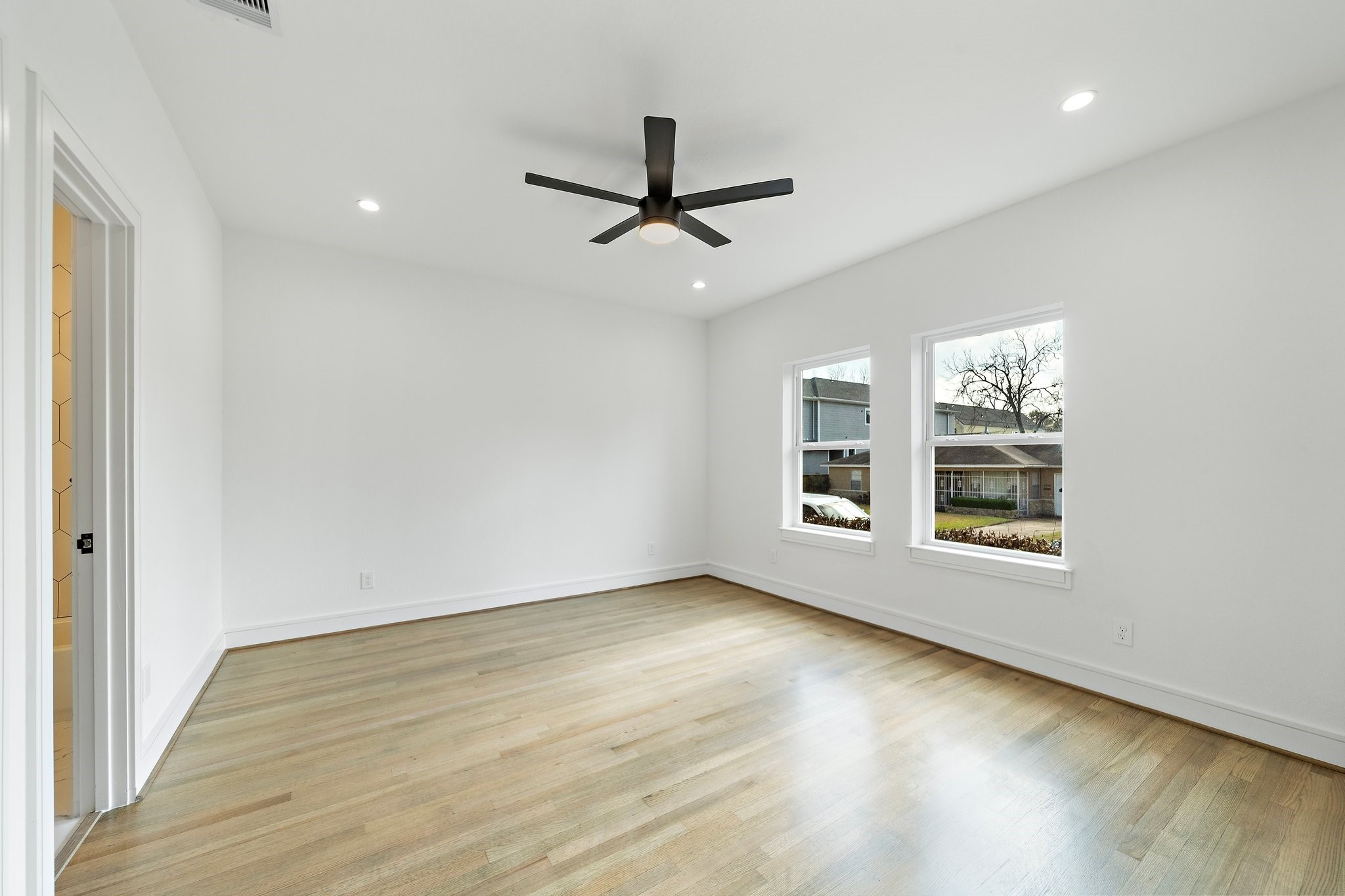 1005 East 28th Street Houston, TX 77009 - Photo 34 of 35 an empty room with wooden floor ceiling fan and windows