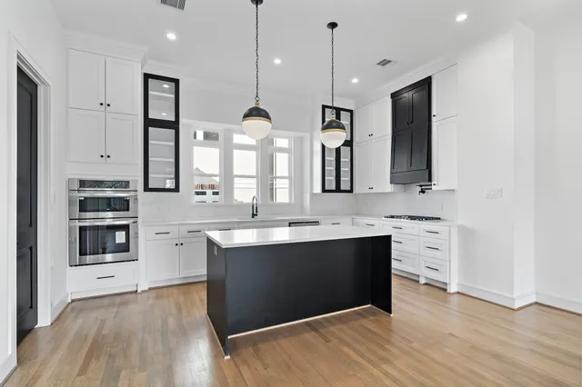 a large kitchen with kitchen island a sink stainless steel appliances and cabinets