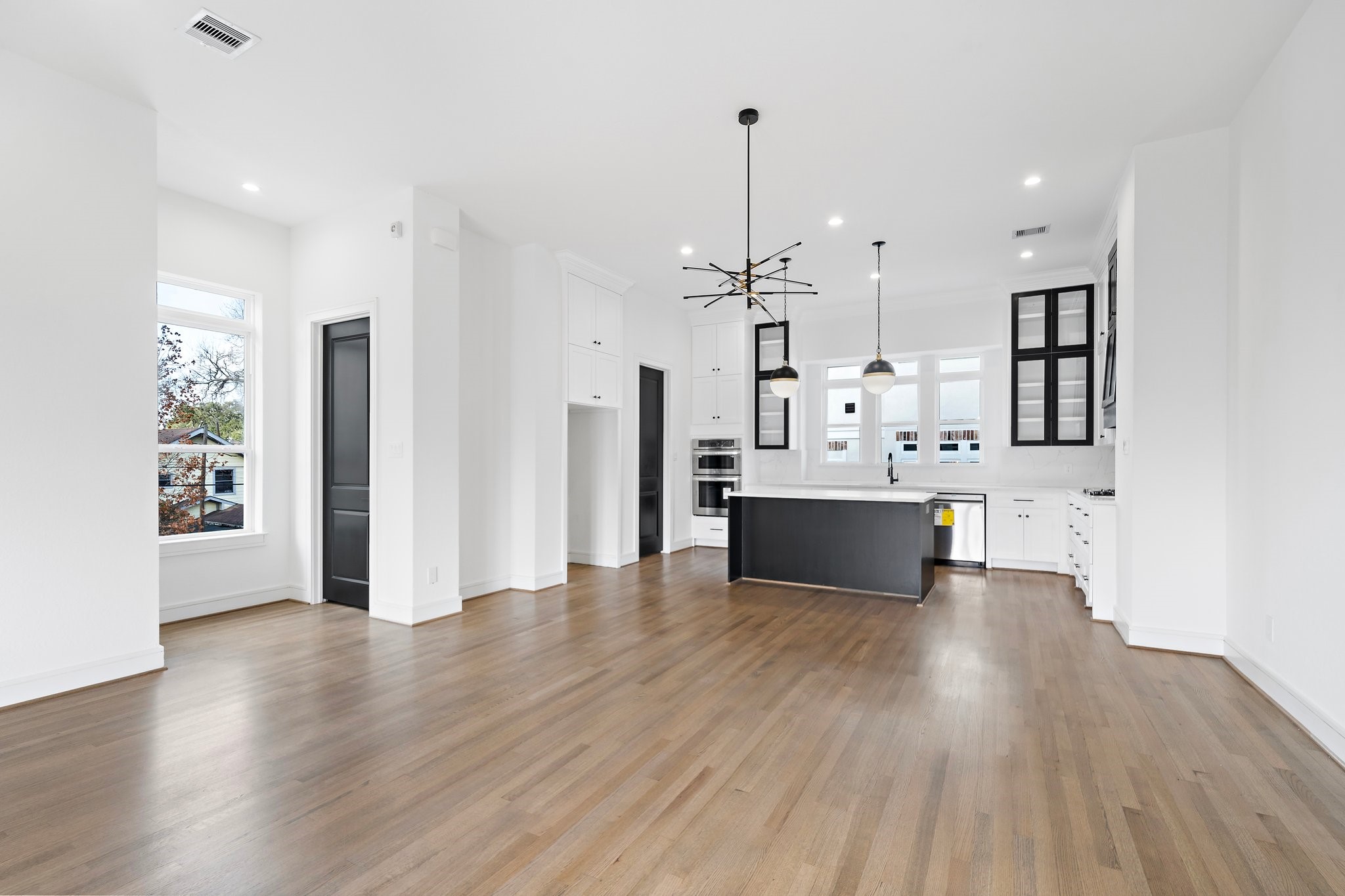 1005 East 28th Street Houston, TX 77009 - Photo 10 of 35 a large white kitchen with a large window and stainless steel appliances