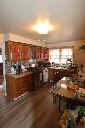 a kitchen with stainless steel appliances granite countertop a stove refrigerator and dining table with granite countertops