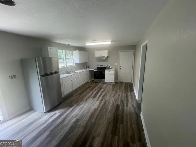 a kitchen with white cabinets and white appliances
