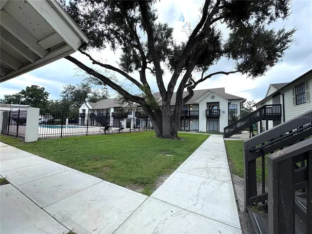 a view of a house with backyard and tree