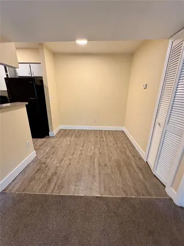 an empty room with wooden floor and staircase