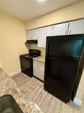 a kitchen with a refrigerator and a stove