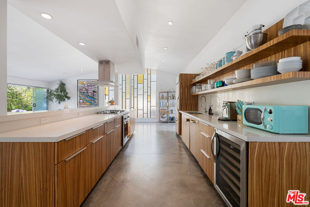 1155 East Mesquite Avenue Palm Springs, CA 92264 - Photo 7 of 32 a kitchen with stainless steel appliances a sink and a wooden floor