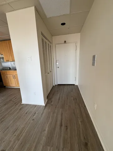 a view of a hallway to a house with wooden floor