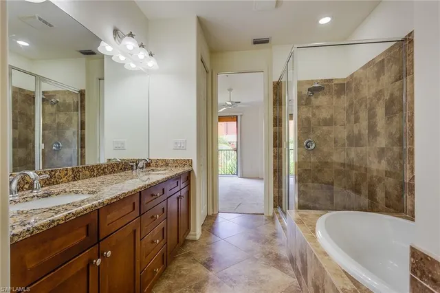 a spacious bathroom with a granite countertop tub sink shower and a mirror