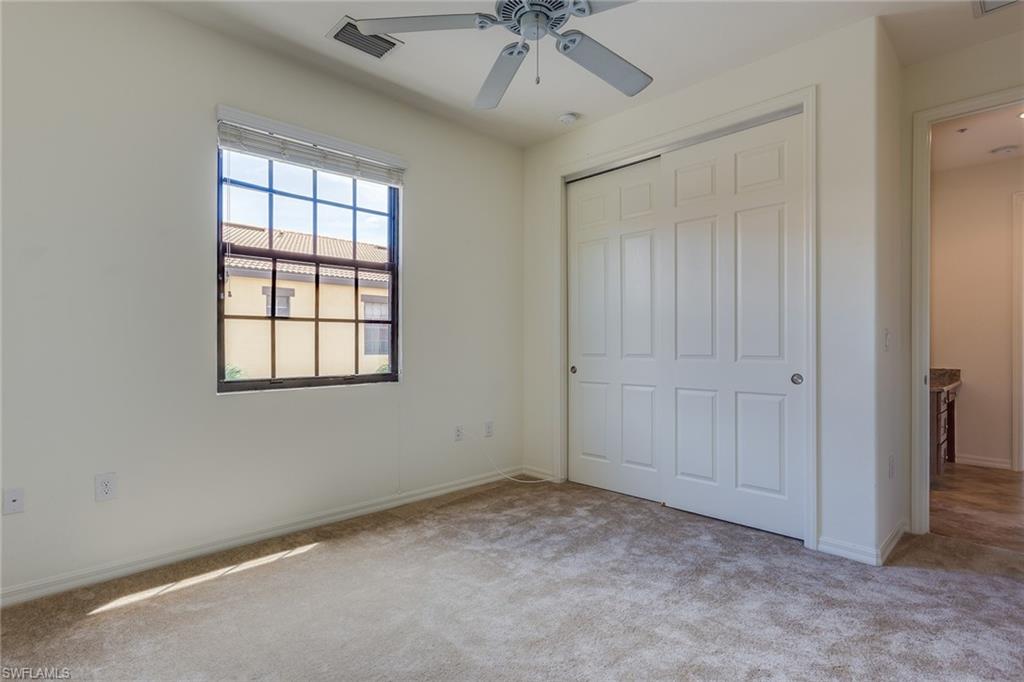 9037 Alturas Street, Unit 372 Naples, FL 34113 - Photo 18 of 23 an empty room with a ceiling fan and windows