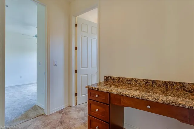a view of kitchen island with granite countertop cabinets and sink