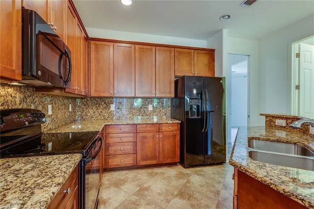 a kitchen with granite countertop wooden cabinets and a stove top oven