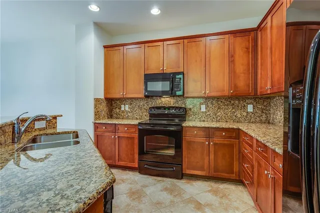 a kitchen with stainless steel appliances granite countertop a stove a sink and a microwave