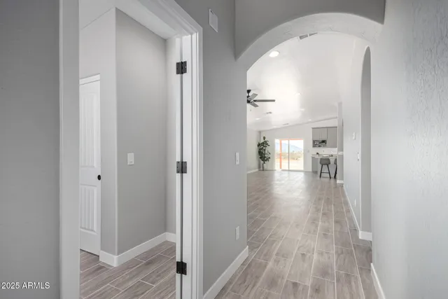 a kitchen with stainless steel appliances granite countertop a stove top oven a sink dishwasher a dining table and chairs with wooden floor