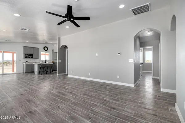 a kitchen with stainless steel appliances granite countertop a stove top oven a sink dishwasher a dining table and chairs with wooden floor