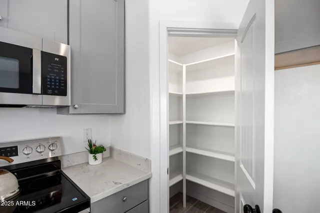 a kitchen with a sink and a stove top oven with wooden floor