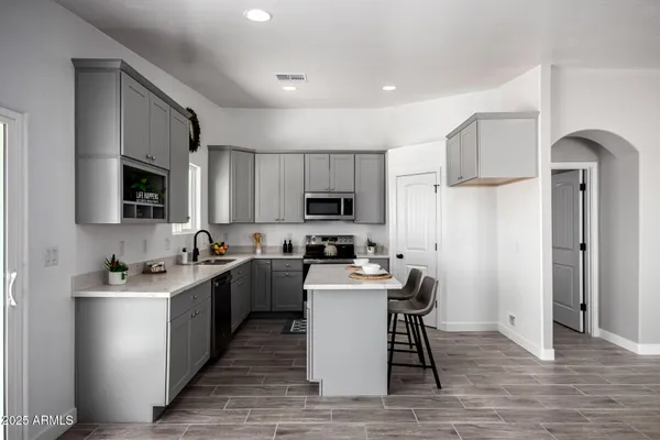 a kitchen with a sink and a stove top oven with wooden floor