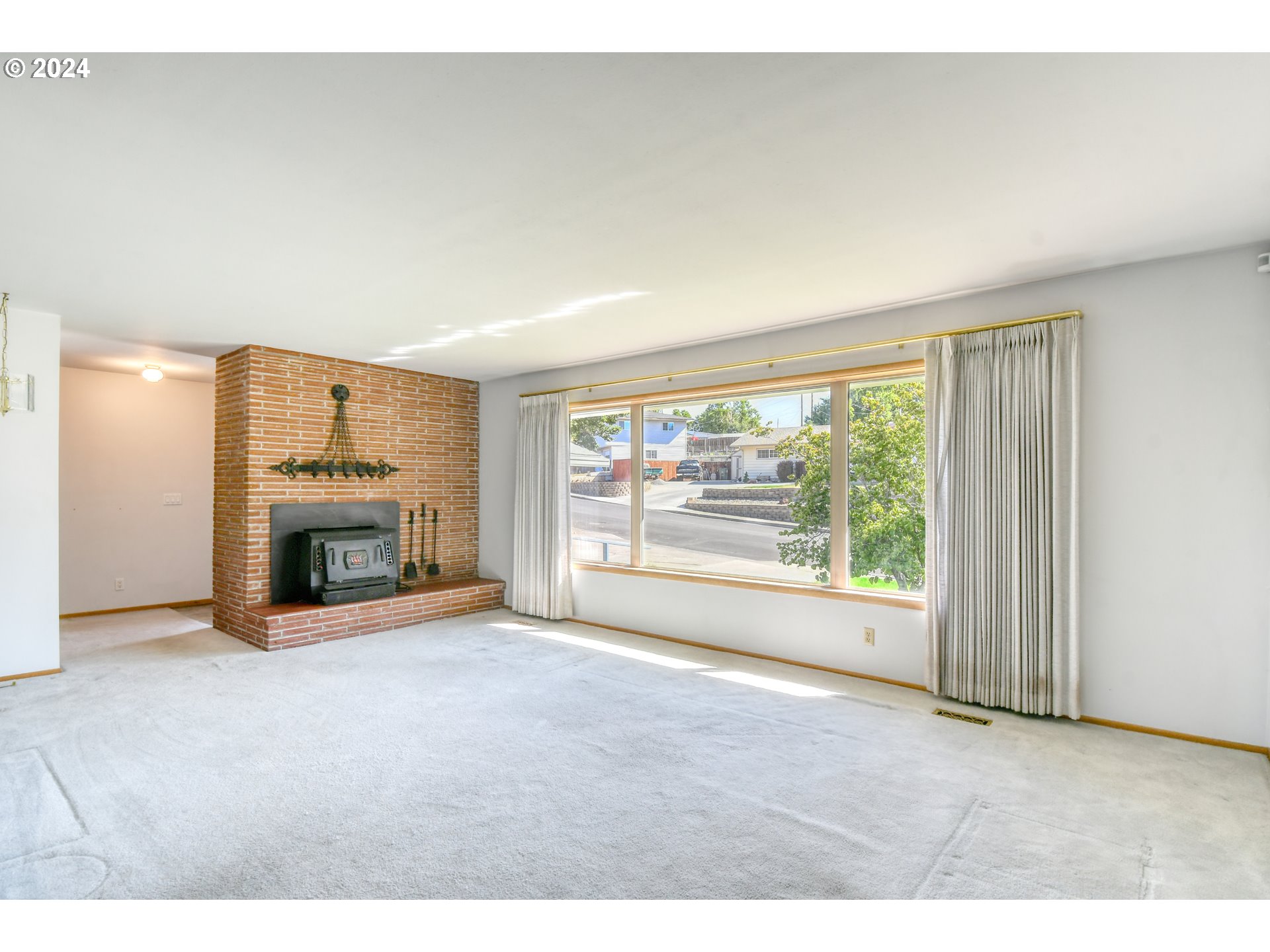 3239 Southwest Isaac Avenue Pendleton, OR 97801 - Photo 3 of 42 a view of an empty room with a fireplace and a window
