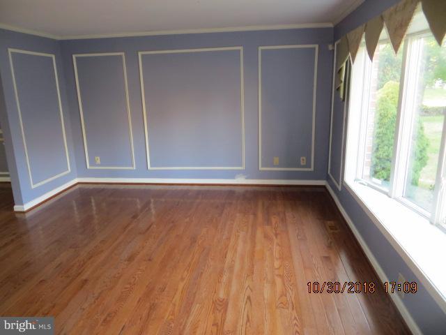 6923 Pinecrest Road Baltimore, MD 21228 - Photo 2 of 14 an empty room with wooden floor and windows
