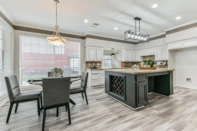 a kitchen with a table chairs and wooden floor