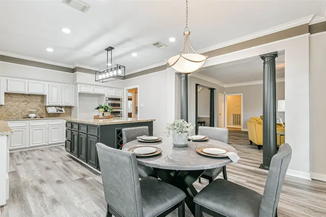 a view of a dining room with furniture a chandelier and wooden floor