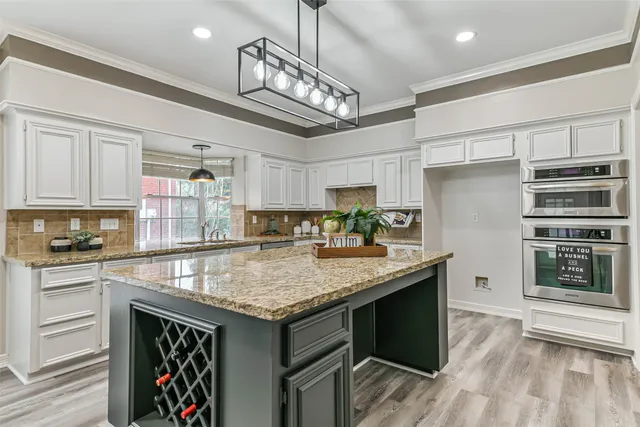 a kitchen with stainless steel appliances granite countertop a stove refrigerator and cabinets
