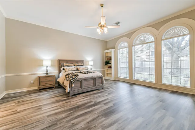 a bedroom with a large bed and wooden floor