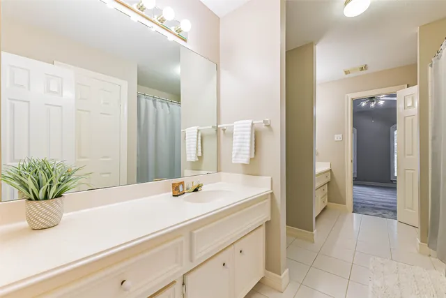 a bathroom with a granite countertop sink a mirror and a shower