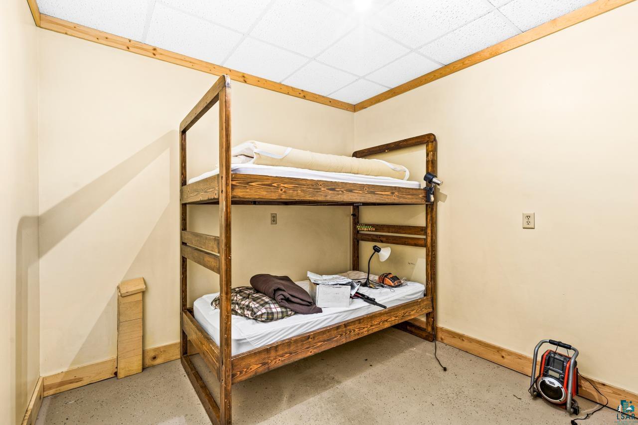 4800 Tower Road Moose Lake, MN 55767 - Photo 74 of 83 Room with wood-finish bunk beds, light-colored walls, wood trim, and a grid ceiling