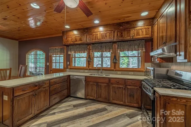 a large kitchen with stainless steel appliances granite countertop a stove and a sink
