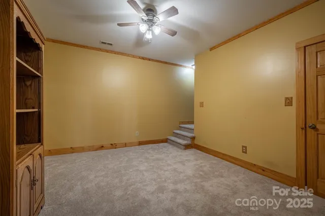 an empty room with a ceiling fan and a window