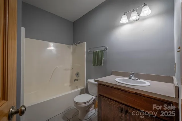 a bathroom with a sink a toilet a mirror and shower