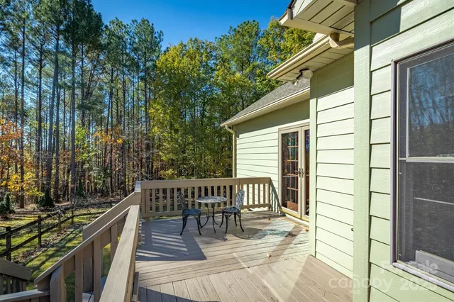 a view of a balcony with two chairs and wooden fence