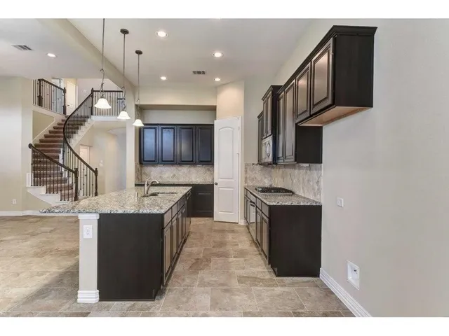 a kitchen with stainless steel appliances granite countertop a stove a sink and a microwave