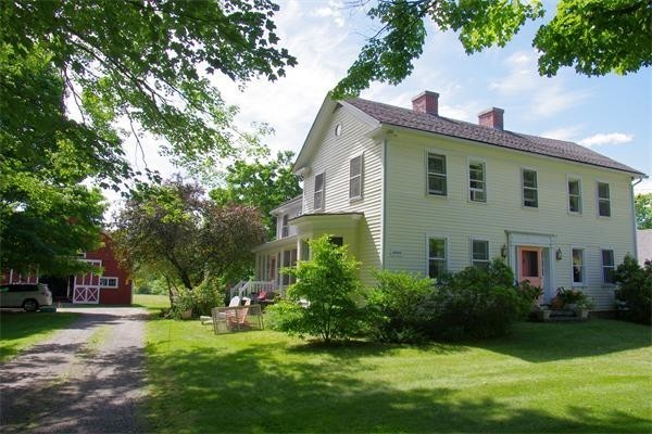 a front view of a house with a yard and trees