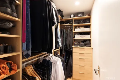 a view of walk in closet with clothes and shoes