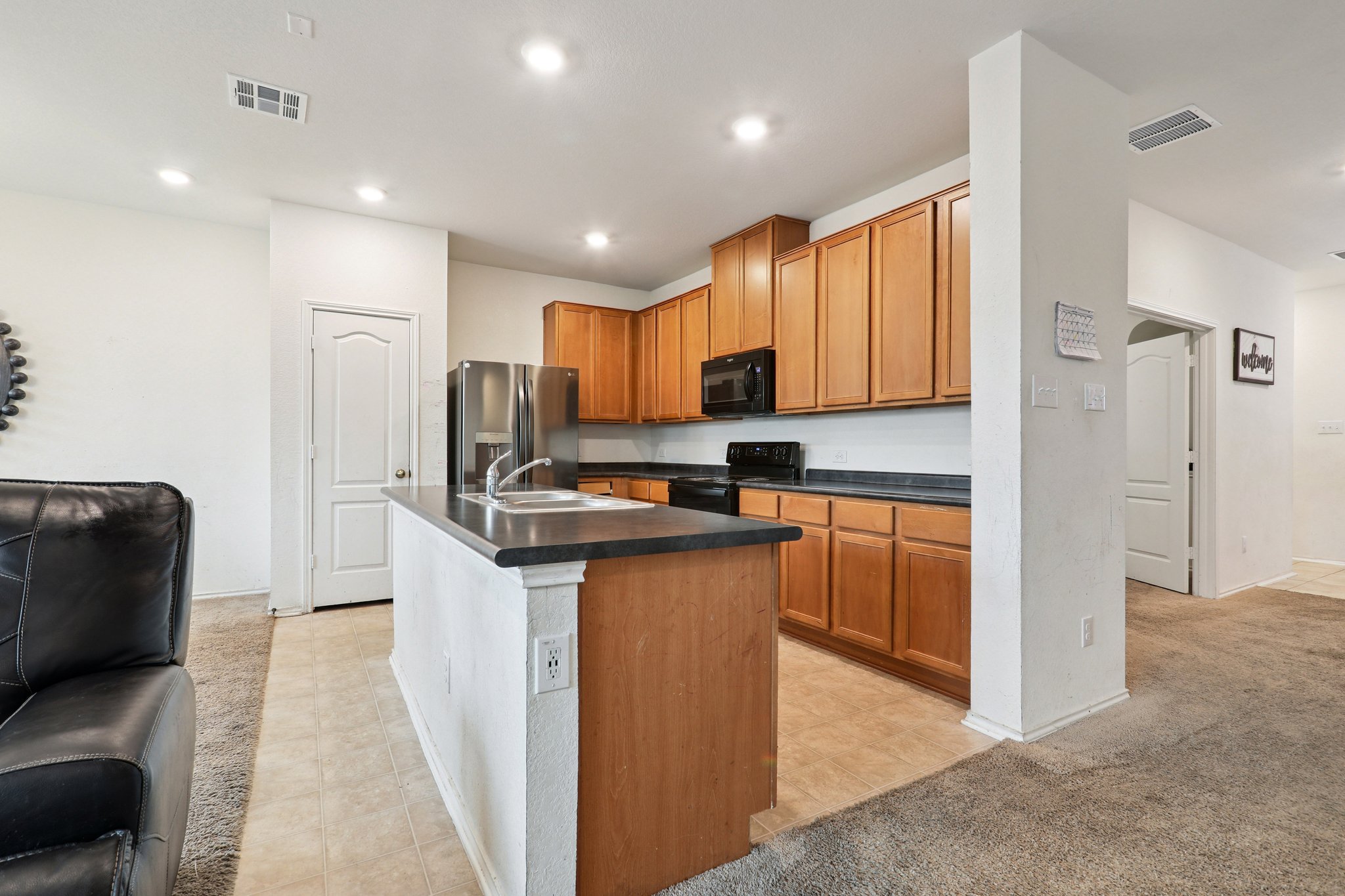 13817 Eleanor Roosevelt Street Manor, TX 78653 - Photo 11 of 35 a kitchen with stainless steel appliances granite countertop a refrigerator sink and cabinets