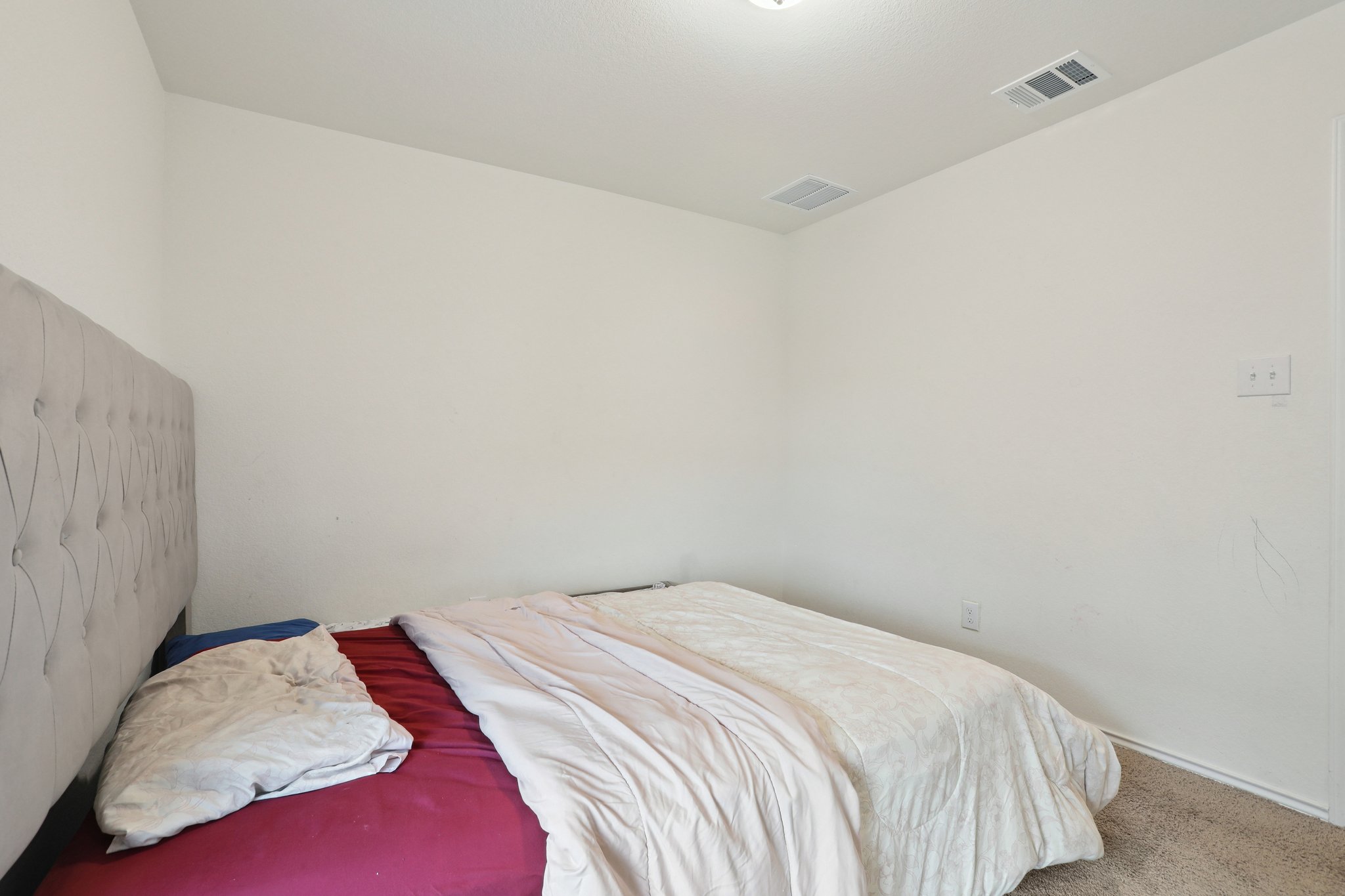 13817 Eleanor Roosevelt Street Manor, TX 78653 - Photo 19 of 35 a bedroom with a bed and a white wall