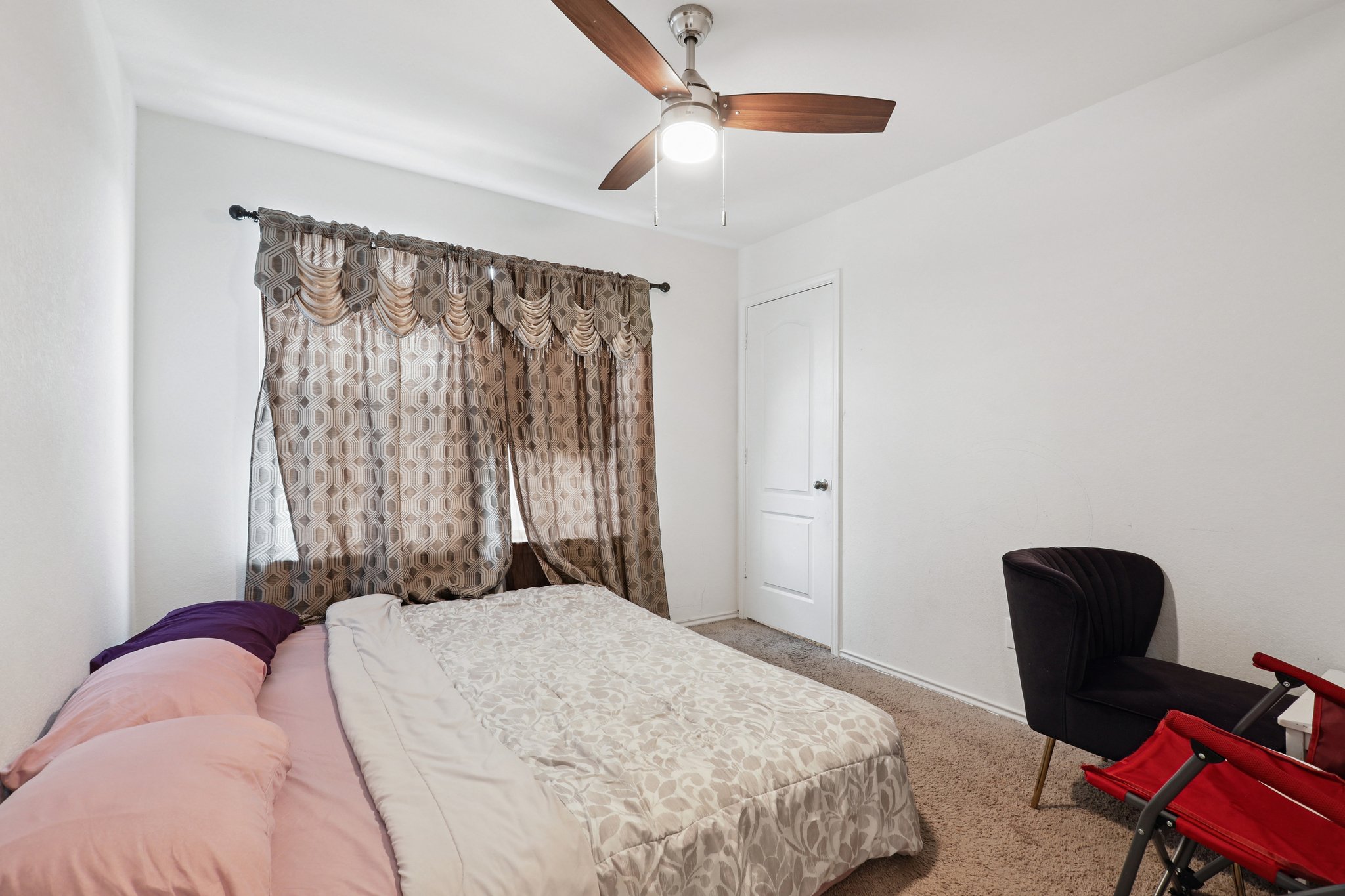 13817 Eleanor Roosevelt Street Manor, TX 78653 - Photo 22 of 35 a bedroom with a bed and a chair