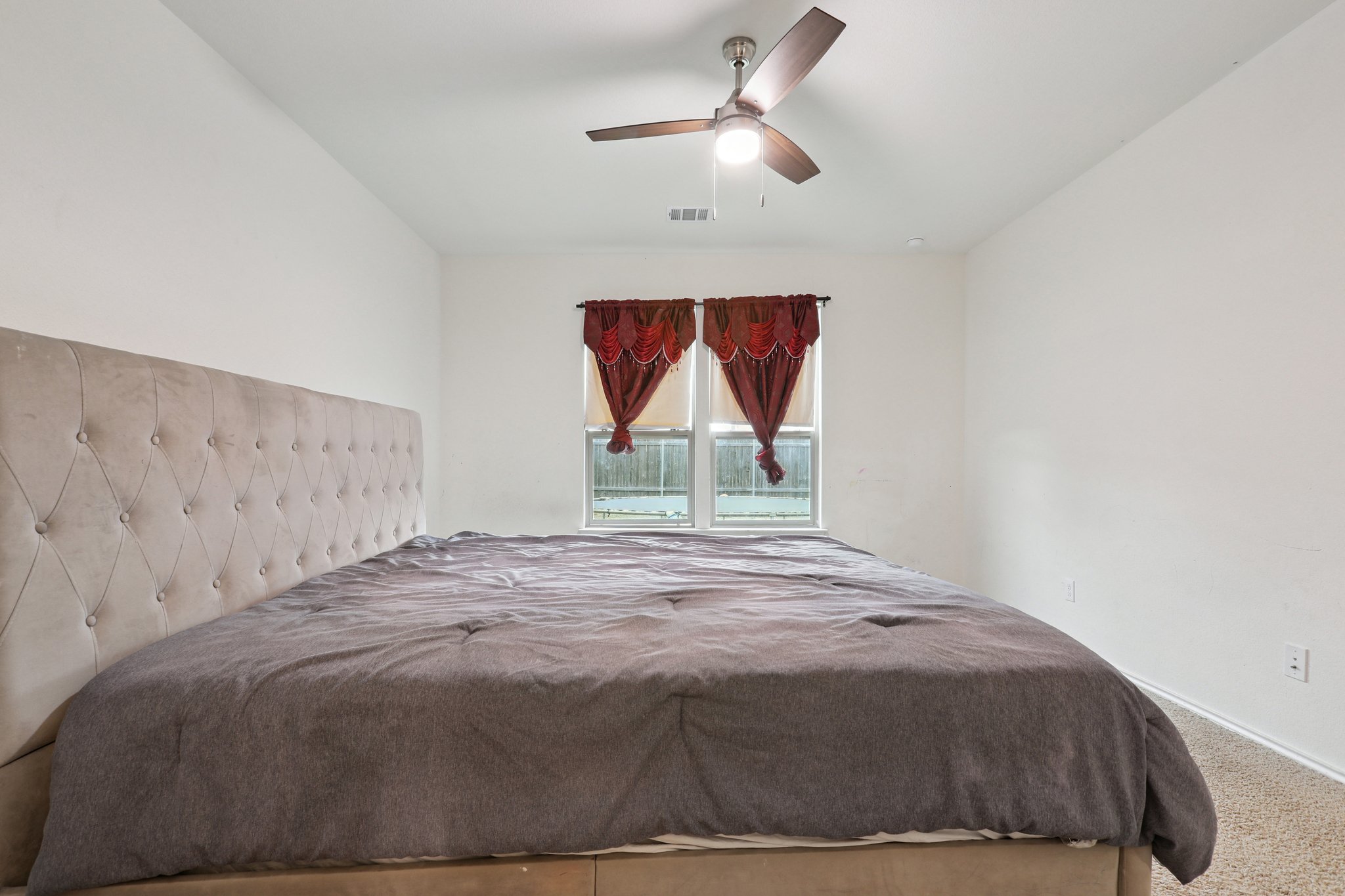 13817 Eleanor Roosevelt Street Manor, TX 78653 - Photo 26 of 35 a bed sitting in a bedroom next to a window