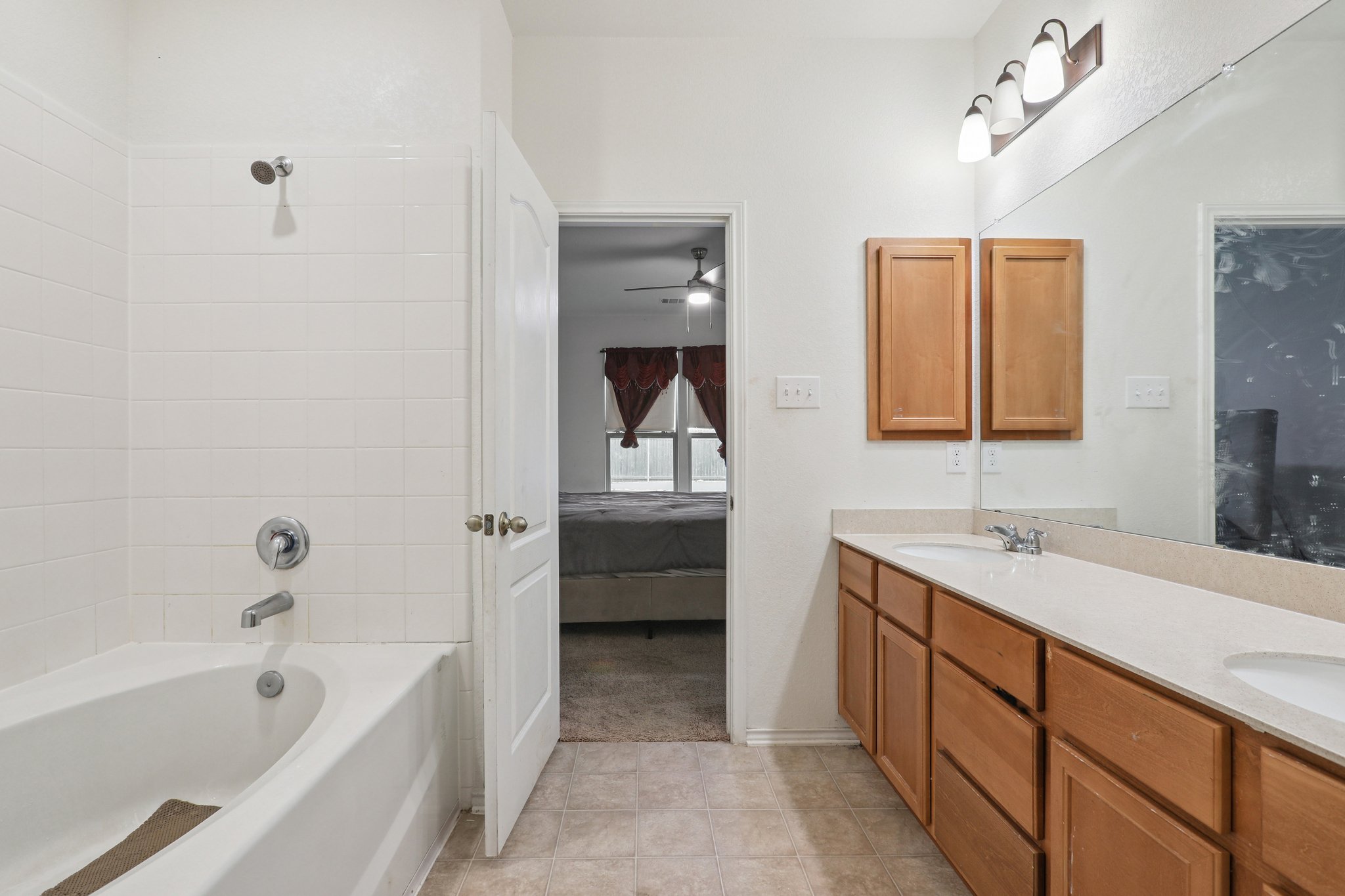 13817 Eleanor Roosevelt Street Manor, TX 78653 - Photo 28 of 35 a bathroom with a tub sink and mirror