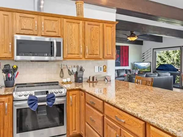 a kitchen with stainless steel appliances granite countertop a sink stove and cabinets